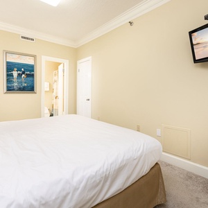 Relaxing guest bedroom featuring a plush king bed, tasteful decor, and a wall-mounted TV