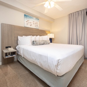 Retreat to the serene bedroom featuring a plush king bed, soft carpet, and a flat-screen TV for your relaxation