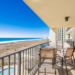 Balcony seating offers a serene view of the beach and turquoise waters, perfect for relaxing in the sun