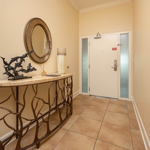 The entryway features a stylish table, decorative mirror, and artistic fish sculpture, setting a pleasant tone for your stay