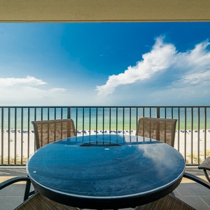 Savor your morning coffee at the balcony table, with expansive views of the tranquil waters and beach below