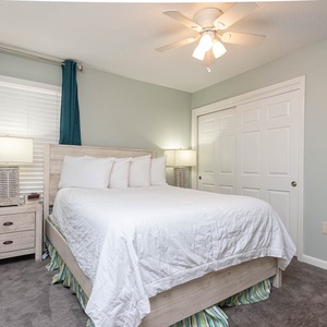 This cozyguest bedroom features soft teal accents, a plush queen bed, and a wall-mounted TV for your entertainment