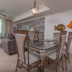 Dine comfortably at the elegant glass table, surrounded by stylish chairs and vibrant fish decor