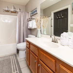 Refresh in this guest bathroom featuring a spacious vanity, soft towels, and nautical decor for a relaxing experience