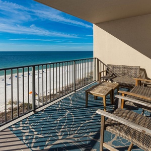 Relax on the balcony with comfortable seating and enjoy the expansive views of the tranquil waters and beach below