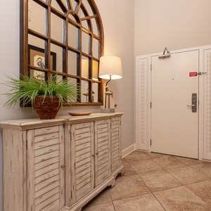 This welcoming entryway features a stylish console table, a decorative mirror, and a soft lamp, perfect for a warm arrival