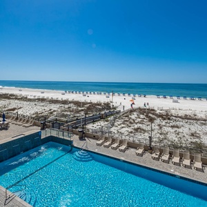 Enjoy the refreshing pool area with ample lounge chairs, leading to a beautiful stretch of beach just steps away