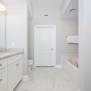 Experience relaxation in the master bathroom featuring a spacious vanity, soothing tub, and walk-in shower