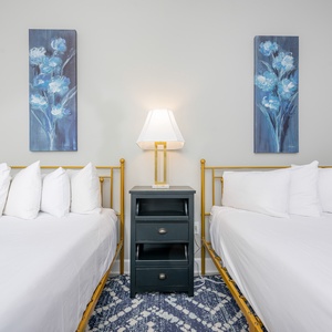 Stretch out on either queen bed, enjoy a good book, and admire tall blue botanical paintings above
