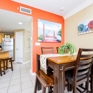 Gather around the wooden dining table, surrounded by vibrant decor and a view that invites relaxation and connection