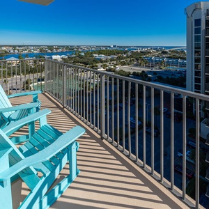 Bright turquoise chairs on the balcony offer a relaxing spot to enjoy views of the surrounding area and distant gulf waters