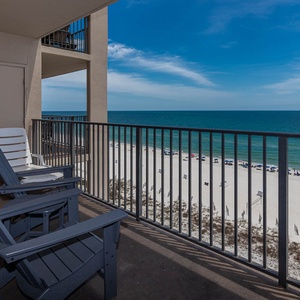 Relax in comfortable chairs on the balcony, enjoying expansive views of the water and gentle waves lapping at the shore