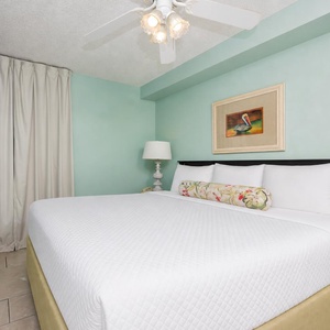 Enjoy restful nights in this serene bedroom suite featuring a plush king bed, soft lighting, and a flat-screen TV