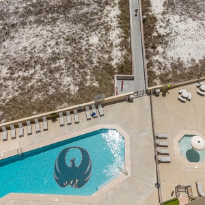 Aerial balcony view of the inviting pool area featuring lounge chairs, a shaded gazebo, and easy access to the beach