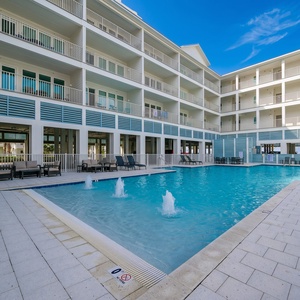 Relax by the sparkling pool, just steps from the beach, with lounge chairs perfect for soaking up the sun at Sea Glass