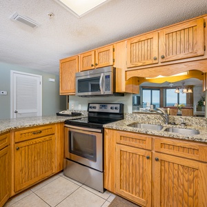 Prepare meals in the spacious kitchen featuring granite countertops, wooden cabinetry, and stainless appliances