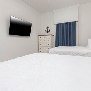 Stream shows from your queen bed while taking in the anchor wall art and coastal vibe