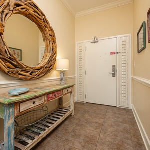 This welcoming entryway features a rustic wooden mirror, colorful console table, and soft lighting for a warm ambiance