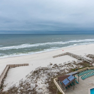 Stunning view of the serene beach and gentle waves from a balcony, perfect for relaxing and enjoying coastal serenity