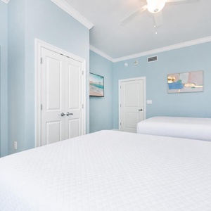 Tranquil guest bedroom featuring two comfortable queen beds, soft linens, and coastal decor for a relaxing stay