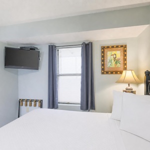 Relax in a comfortable bed with a mounted TV, and charming artwork, perfect for a relaxing stay