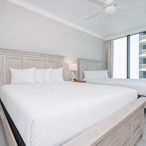 Rest comfortably in this serene guest bedroom featuring two queen beds, soft linens, and stunning views