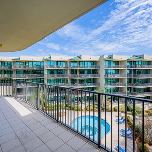Bask in the coastal breeze from your spacious balcony, soaking in serene views of the lush surroundings and pool area