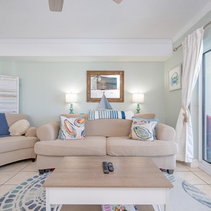 Living space featuring a cozy sofa, decorative pillows, and natural light from sliding glass doors