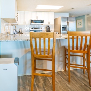 Warm light from the overhead fixture invites you to gather around the breakfast bar in the kitchen