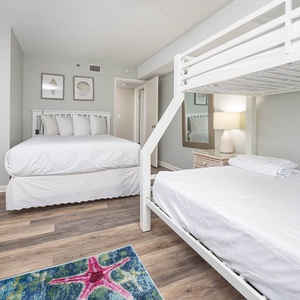 Cheerful guest bedroom featuring a queen bed, bunk beds, and vibrant decor for a fun getaway