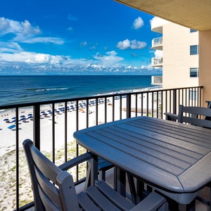 Have a relaxing moment on the balcony with comfortable seating and a breathtaking view of the sandy beach and blue waters