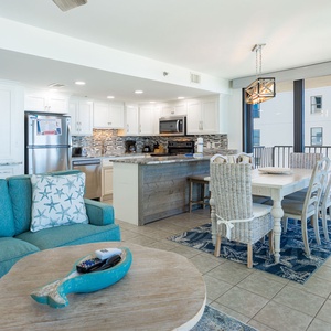 Relax in the inviting living space featuring a cozy sofa, dining area, and a stylish kitchen