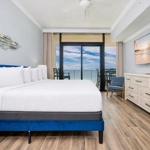 Relax in the master suite featuring a king bed, large TV, and beachfront balcony access