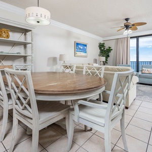 Gather around the round dining table, surrounded by coastal decor and a view that invites relaxation and connection