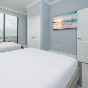 Rest in this comfortable guest room with two queen beds, a large TV, and expansive windows