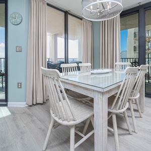 Enjoy meals at the glass-top dining table surrounded by natural light and views of the beach from the balcony