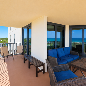 Inviting balcony seating with blue cushions offers a perfect spot to relax while enjoying views of the beach