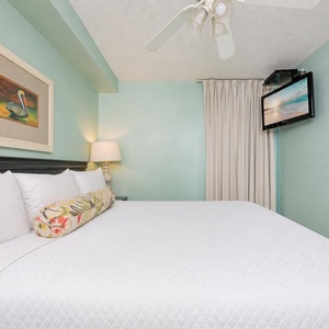 Fluffy pillows invite you to relax in the king suite for a calm movie night after a fun day at the beach