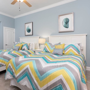 Rest comfortably in this inviting quest bedroom, where two queen beds await your sleep after a day at the beach