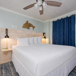 Relaxing master bedroom featuring a cozy king bed with white linens and charming coastal decor, perfect for relaxation