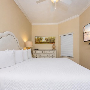 Relax in the inviting guest suite, where plush bedding and a wall-mounted TV create a perfect retreat for restful nights