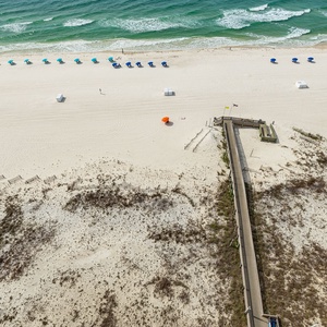 Gaze at the inviting shoreline with colorful umbrellas and soft sands, perfect for a day of relaxation and fun