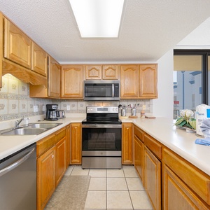 Warm wooden cabinetry and black and stainless appliances complement the spacious kitchen with a breakfast bar