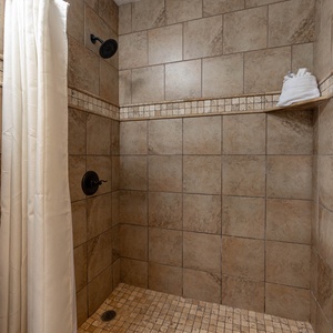 Enjoy a refreshing walk-in shower in the spacious tiled master bath, featuring elegant tile and decor
