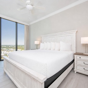 Relax in this guest bedroom featuring a plush king bed, stylish lamp, and expansive windows with stunning views