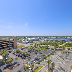 Expansive view of the marina and lush greenery under a clear blue sky from the balcony of this beachfront corner condo