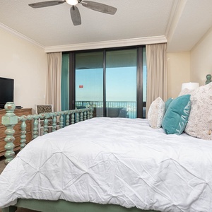 Relax in the inviting master bedroom with a king bed, plush pillows, and a view through sliding glass doors