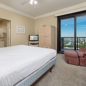 Inviting guest bedroom featuring a king bed, a TV, and balcony access with area views