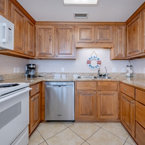 Warm wood cabinetry complements the spacious kitchen, featuring a breakfast bar and ample counter space for meal preparation