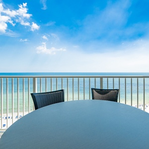 Savor your morning coffee at the round table while enjoying expansive views of the tranquil water and beach below